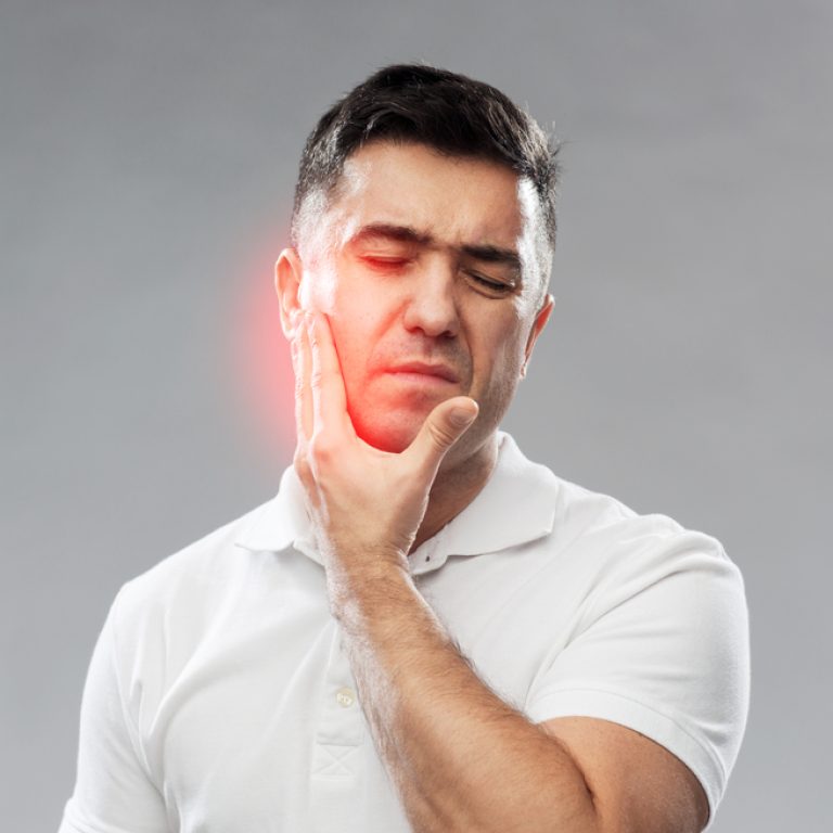 people, healthcare, dentistry and problem concept - unhappy man suffering toothache over gray background